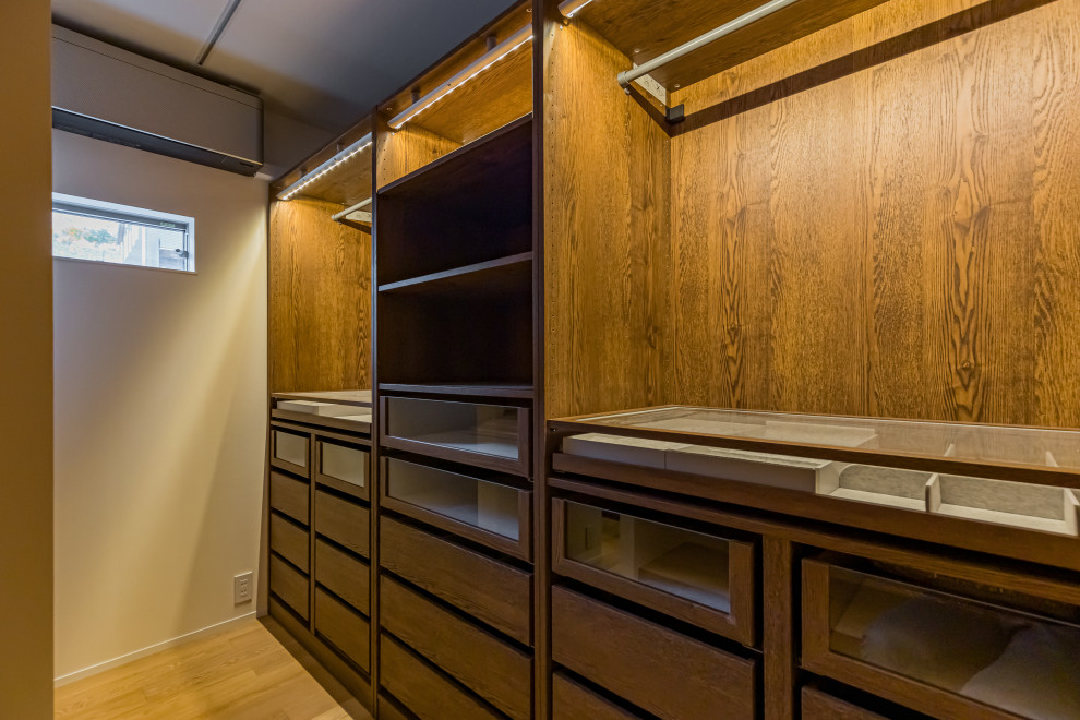 Aménagement d'un dressing room moderne de taille moyenne et neutre avec un sol en bois brun, un sol marron et un plafond en papier peint.