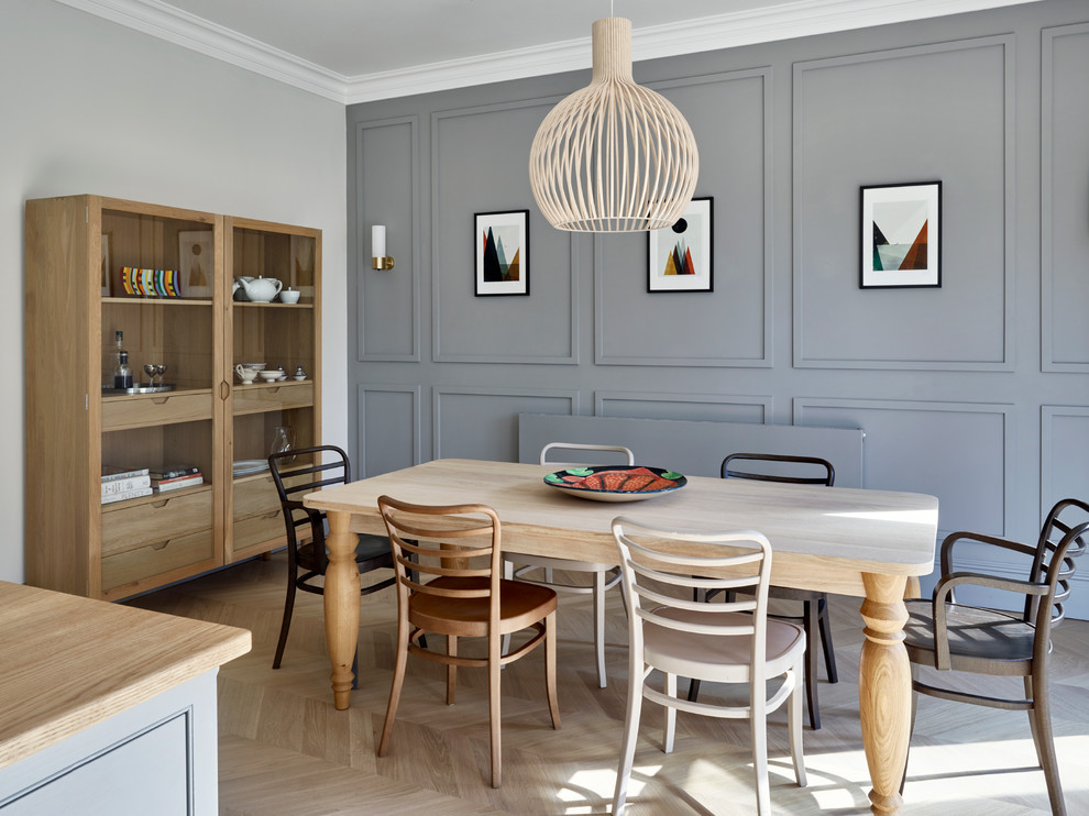 Transitional kitchen/dining combo in London with blue walls and light hardwood floors.