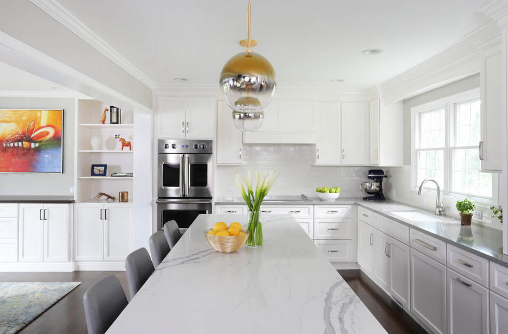 Huge transitional l-shaped dark wood floor and brown floor eat-in kitchen photo in Chicago with an undermount sink, shaker cabinets, white cabinets, quartzite countertops, white backsplash, porcelain backsplash, stainless steel appliances, an island and white countertops
