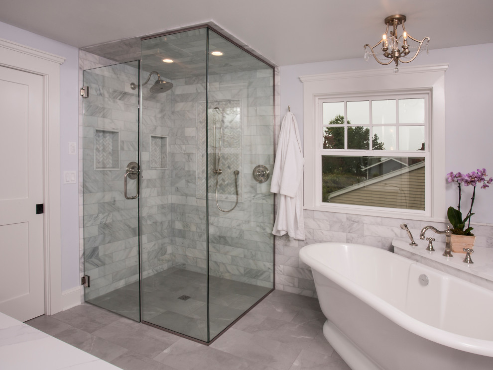 This is an example of a large traditional master bathroom in Seattle with shaker cabinets, white cabinets, a freestanding tub, a curbless shower, a two-piece toilet, white tile, marble, blue walls, porcelain floors, an undermount sink, engineered quartz benchtops, grey floor, a hinged shower door, white benchtops, a niche, a double vanity, a freestanding vanity and decorative wall panelling.