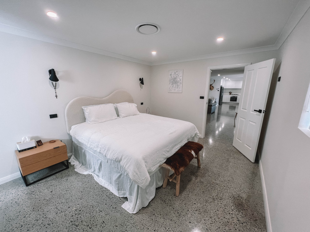 Esempio di una camera matrimoniale nordica di medie dimensioni con pareti bianche, pavimento in cemento, pavimento grigio, soffitto in legno e pareti in legno