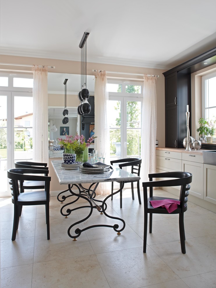 Design ideas for a transitional kitchen/dining combo in Dusseldorf with travertine floors and beige walls.