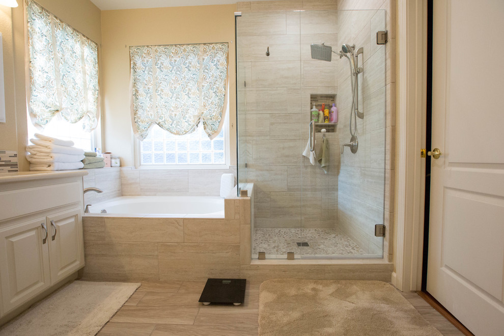 Traditional bathroom in Sacramento with white cabinets, a corner tub, a corner shower, porcelain floors, an undermount sink and a hinged shower door.