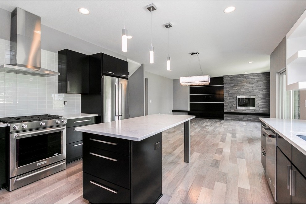 Example of a mid-sized minimalist galley light wood floor and gray floor eat-in kitchen design with a single-bowl sink, flat-panel cabinets, dark wood cabinets, quartzite countertops, white backsplash, glass tile backsplash, stainless steel appliances and an island