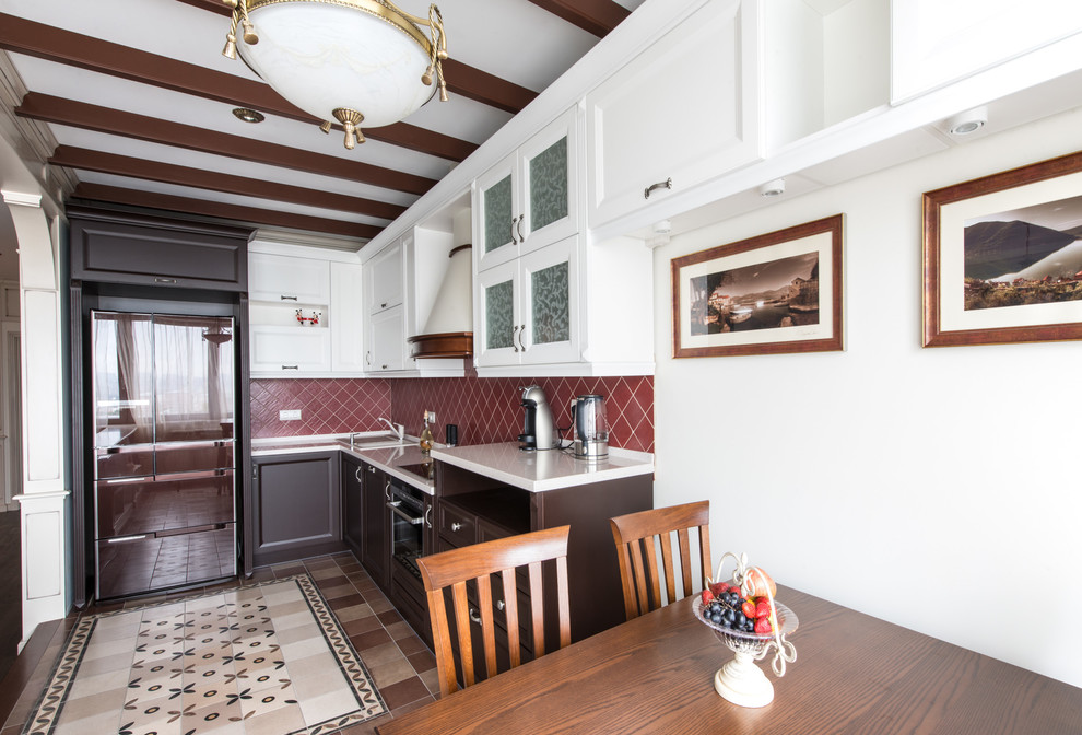 Inspiration for a traditional l-shaped eat-in kitchen in Moscow with recessed-panel cabinets, dark wood cabinets, red splashback, stainless steel appliances, an undermount sink, solid surface benchtops, ceramic floors and no island.