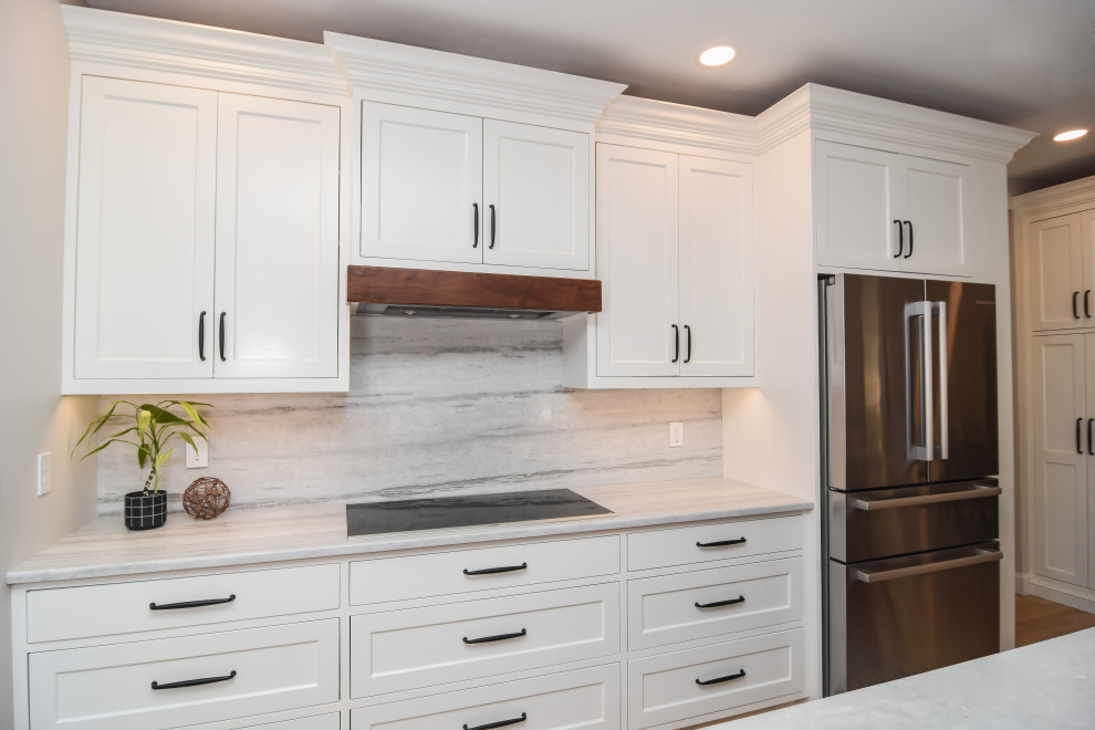 This is an example of a mid-sized transitional single-wall eat-in kitchen in Boston with an undermount sink, shaker cabinets, white cabinets, quartzite benchtops, grey splashback, engineered quartz splashback, stainless steel appliances, with island and white benchtop.