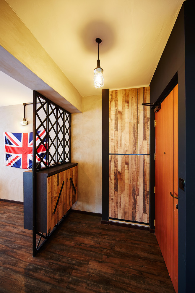 Small industrial entryway in Singapore with grey walls and dark hardwood floors.