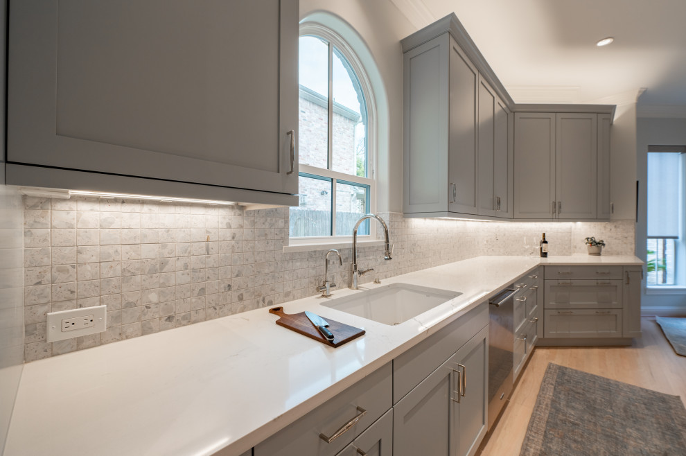 Inspiration for a large transitional u-shaped light wood floor and beige floor eat-in kitchen remodel in Houston with an undermount sink, shaker cabinets, gray cabinets, quartz countertops, ceramic backsplash, stainless steel appliances and white countertops