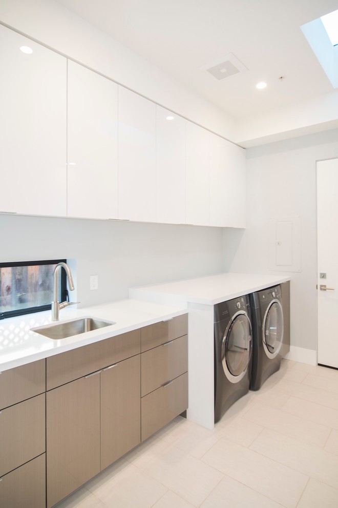 Large contemporary single-wall dedicated laundry room in San Francisco with an undermount sink, flat-panel cabinets, white cabinets, quartz benchtops, white walls, porcelain floors, a side-by-side washer and dryer, beige floor and white benchtop.