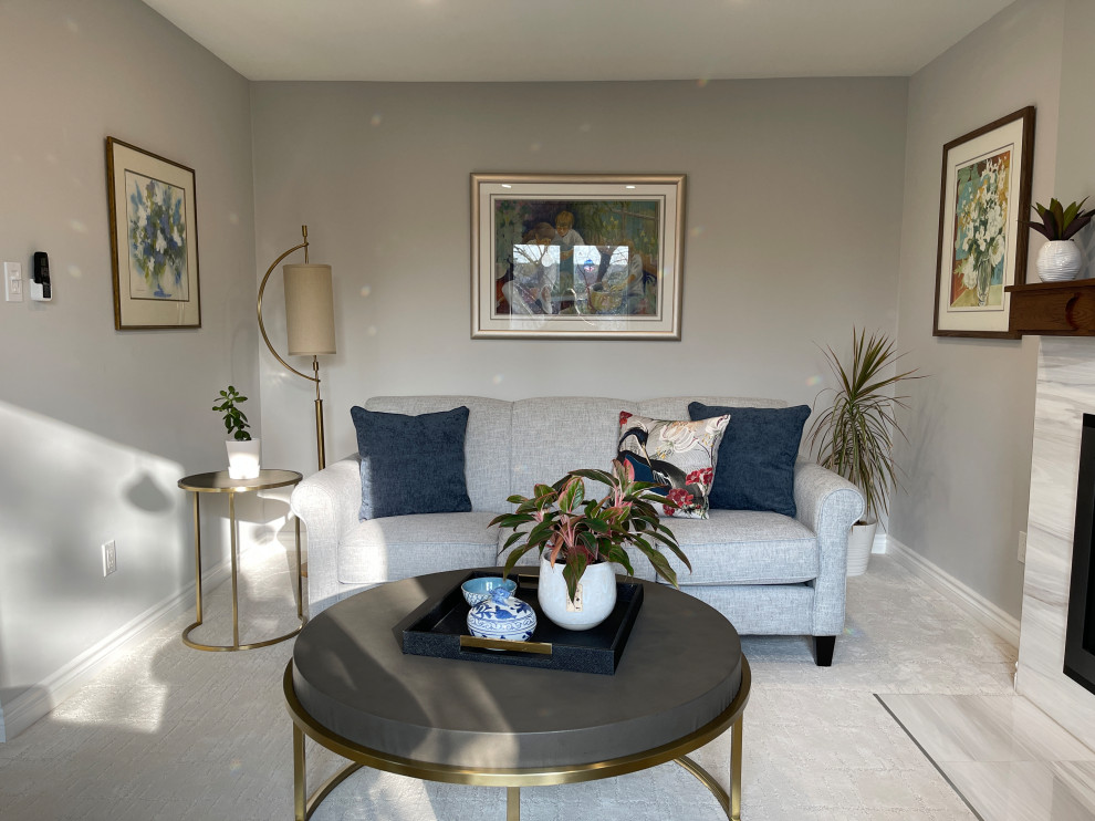 Cette image montre un salon design de taille moyenne et ouvert avec un mur gris, moquette, une cheminée standard, un manteau de cheminée en carrelage et un sol blanc.