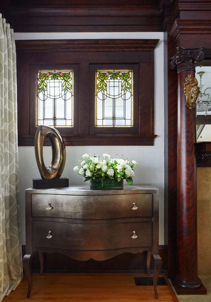 This is an example of a transitional entryway in Minneapolis with white walls and medium hardwood floors.
