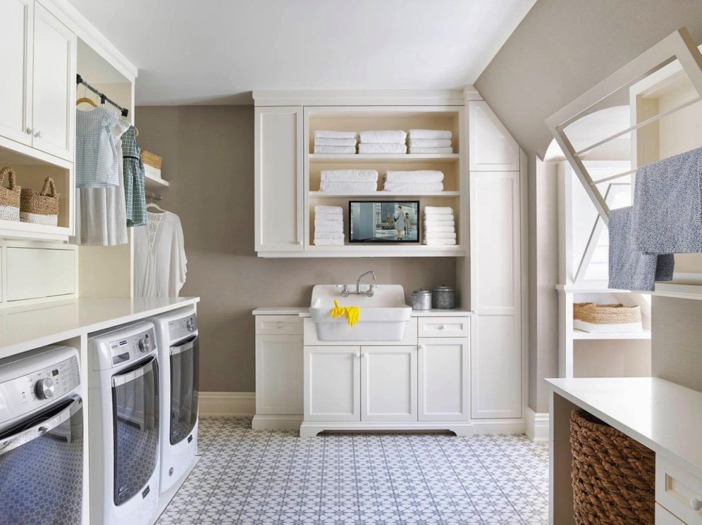 Expansive u-shaped dedicated laundry room in Dallas with a farmhouse sink, shaker cabinets, white cabinets, wood benchtops, beige walls, ceramic floors, a side-by-side washer and dryer, multi-coloured floor and white benchtop.