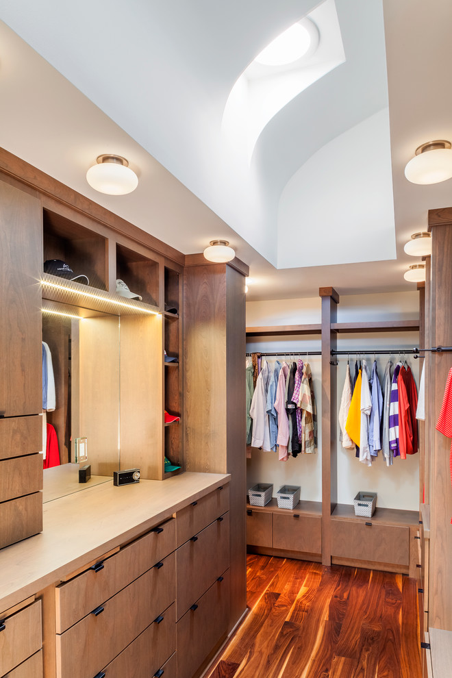 Inspiration for a mid-sized contemporary gender-neutral walk-in wardrobe in Baltimore with medium hardwood floors, open cabinets, dark wood cabinets and brown floor.