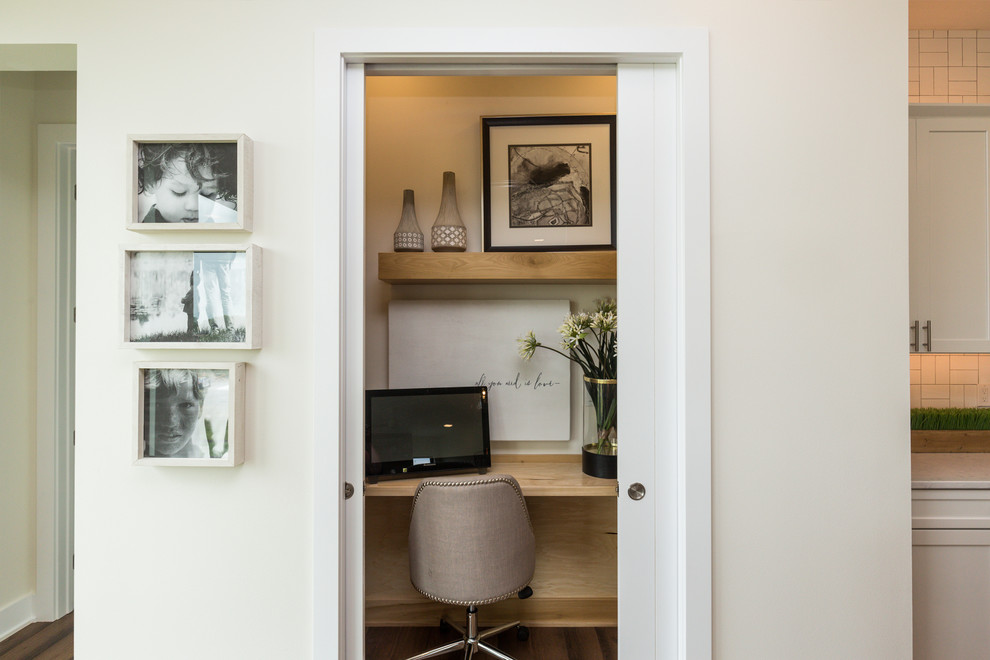 Example of a large transitional built-in desk and l-shaped medium tone wood floor and brown floor eat-in kitchen design with white walls, an undermount sink, shaker cabinets, white cabinets, quartz countertops, white backsplash, subway tile backsplash, stainless steel appliances and an island