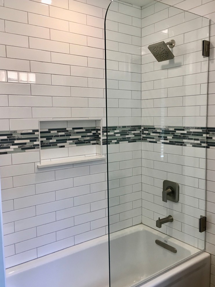 This is an example of a small contemporary kids bathroom in Dallas with shaker cabinets, grey cabinets, an alcove tub, an alcove shower, a two-piece toilet, white tile, ceramic tile, green walls, porcelain floors, an undermount sink, engineered quartz benchtops, brown floor, a hinged shower door and white benchtops.