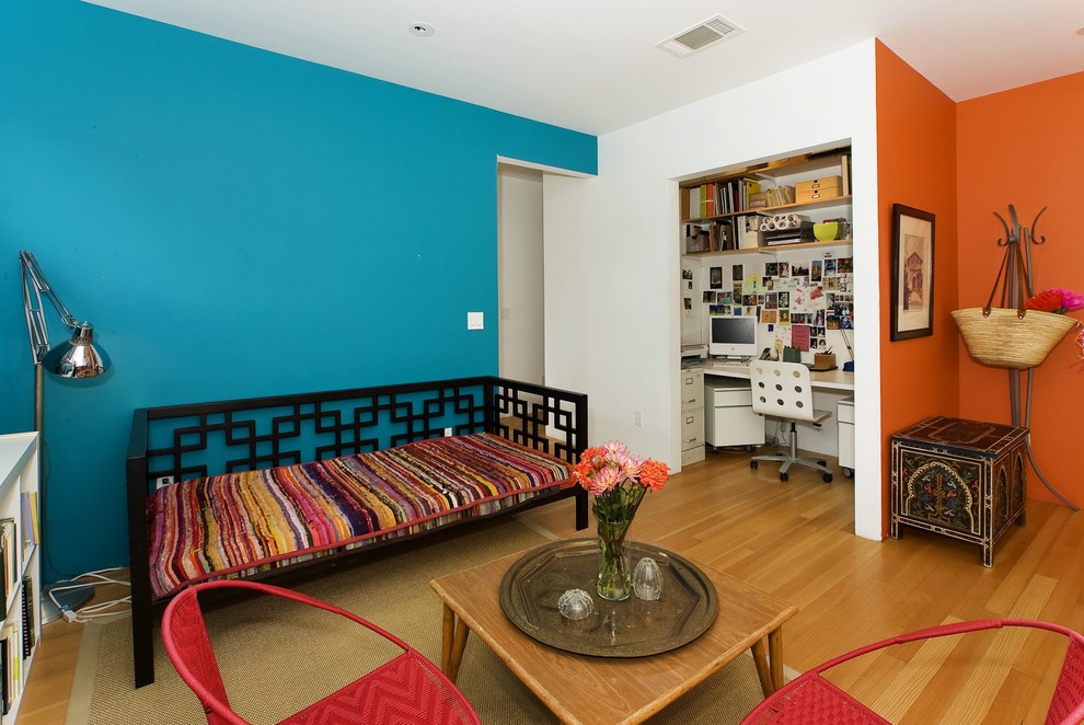 Eclectic home office in San Francisco with blue walls, medium hardwood floors and a built-in desk.