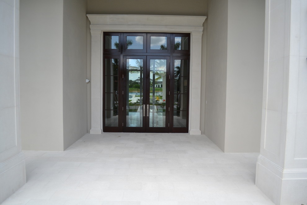 This is an example of a large tropical two-storey concrete grey house exterior in Miami with a tile roof.