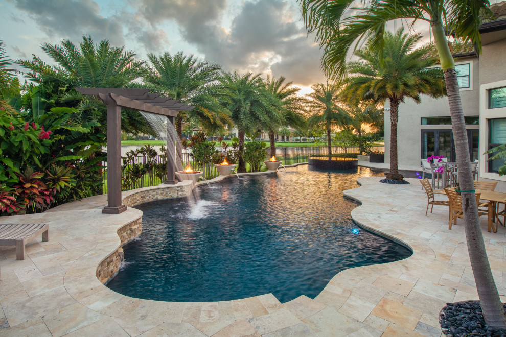 Huge backyard stone and custom-shaped natural hot tub photo in Miami