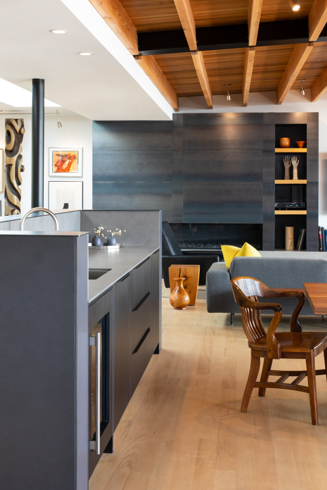 Inredning av ett modernt mellanstort grå grått kök, med en undermonterad diskho, släta luckor, skåp i mörkt trä, bänkskiva i koppar, grått stänkskydd, stänkskydd i porslinskakel, integrerade vitvaror, en köksö och gult golv