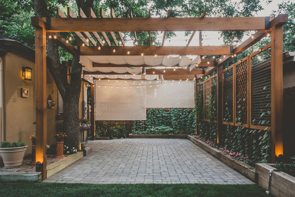 Large traditional backyard patio in Denver with a vertical garden, concrete pavers and a pergola.
