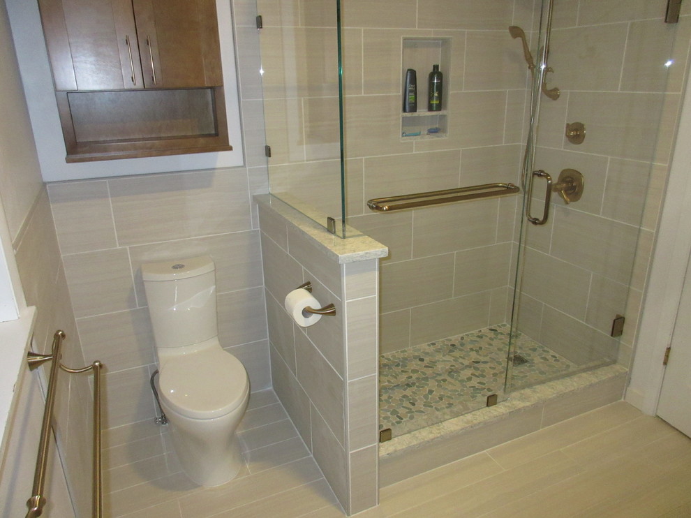 Double shower - mid-sized transitional master beige tile and porcelain tile porcelain tile double shower idea with flat-panel cabinets, medium tone wood cabinets, a two-piece toilet, gray walls, a vessel sink and quartz countertops