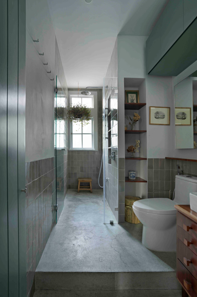 Inspiration for a small traditional 3/4 bathroom in Mexico City with furniture-like cabinets, white cabinets, an alcove shower, a bidet, green tile, ceramic tile, green walls, concrete floors, a vessel sink, wood benchtops, green floor, a hinged shower door, an enclosed toilet, a single vanity, a built-in vanity and recessed.