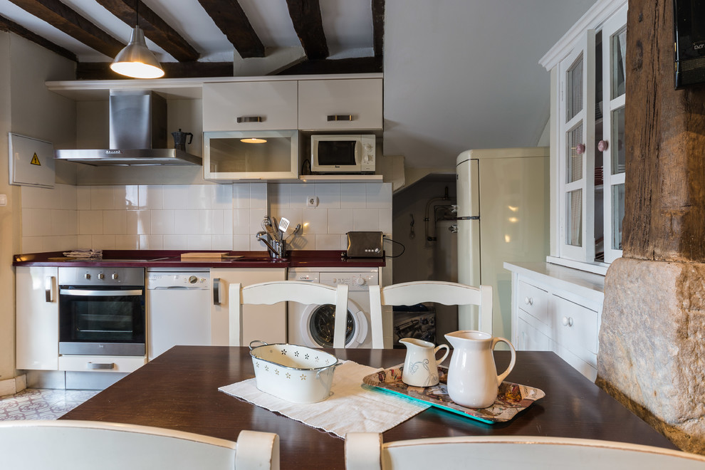 Foto de comedor de cocina rural de tamaño medio sin chimenea con paredes blancas y suelo de baldosas de cerámica