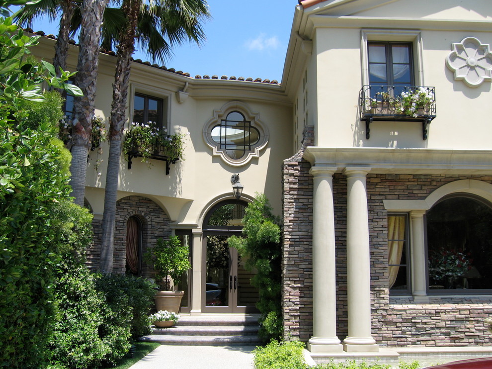 Photo of a traditional two-storey exterior in Los Angeles with stone veneer.