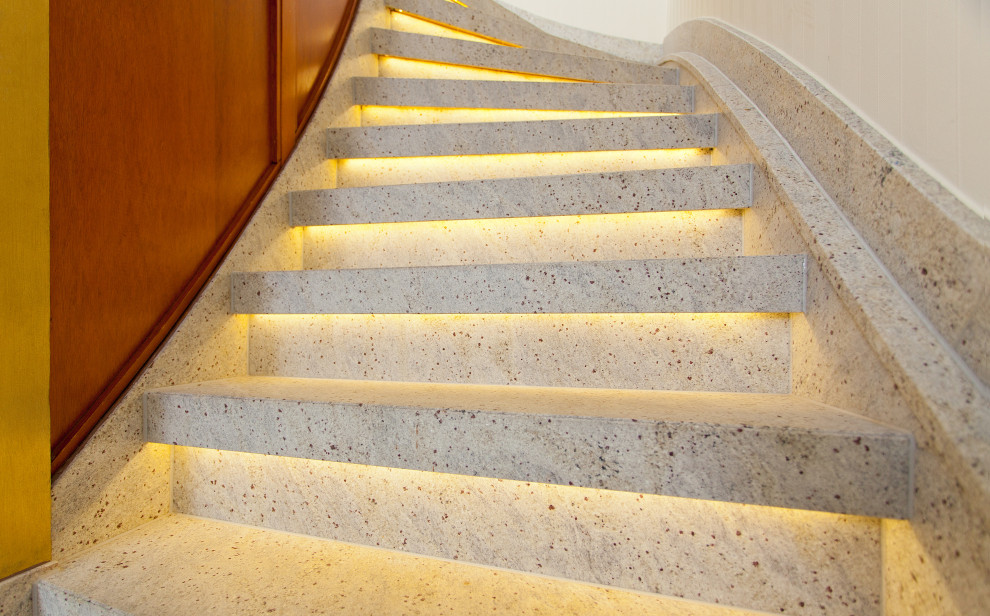 Inspiration for a small country marble curved staircase in Dortmund with marble risers and wood railing.