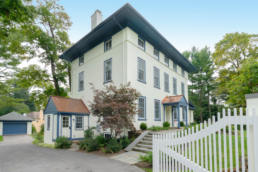 Photo of a large traditional stucco beige house exterior in Philadelphia with four or more storeys, a mixed roof and a grey roof.