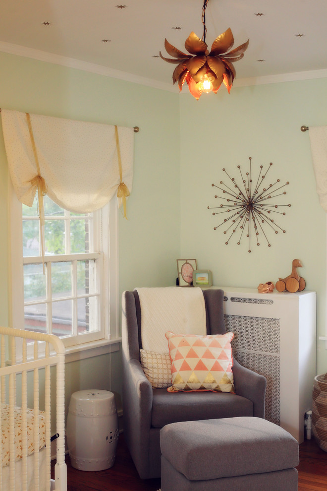 Photo of a mid-sized traditional nursery for girls in Chicago with green walls and medium hardwood floors.