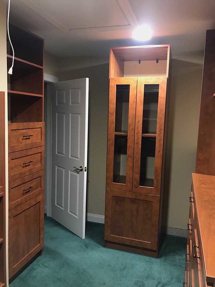 Photo of a mid-sized contemporary men's walk-in wardrobe in Other with shaker cabinets, medium wood cabinets and carpet.