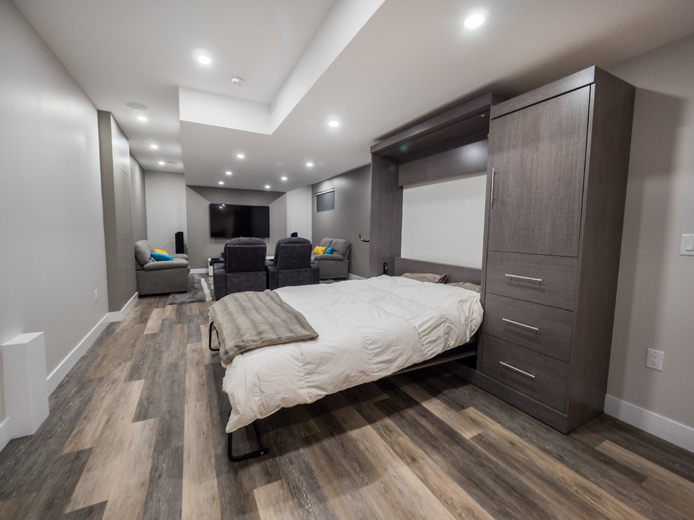 Photo of a mid-sized contemporary look-out basement in Edmonton with grey walls, medium hardwood floors, no fireplace and grey floor.