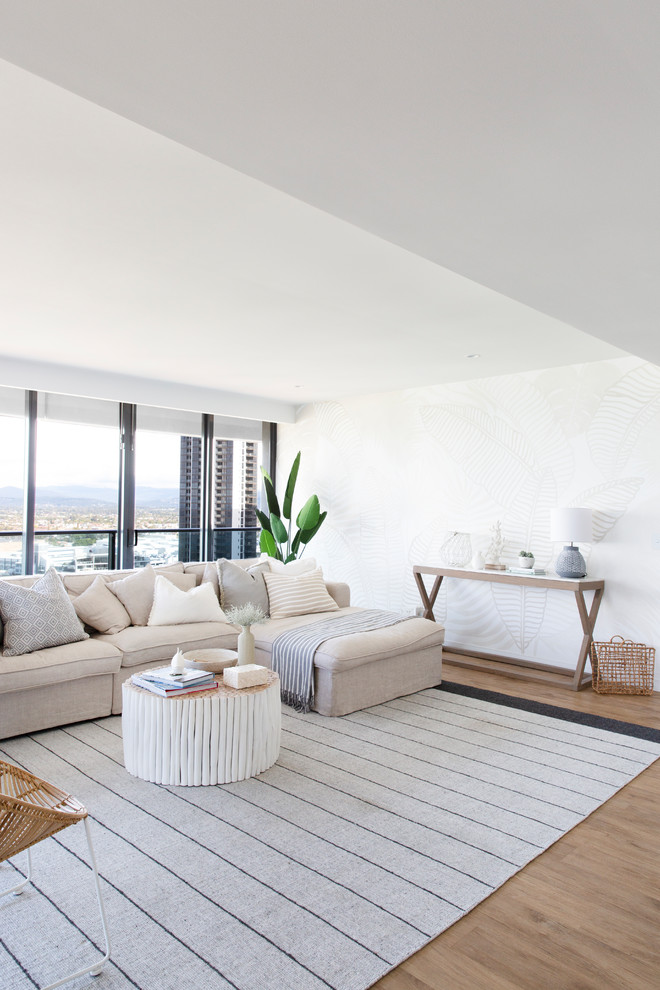Design ideas for an expansive beach style open concept living room in Gold Coast - Tweed with white walls, vinyl floors, a wall-mounted tv and brown floor.