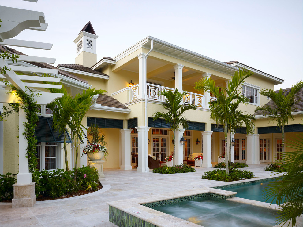 Photo of a tropical two-storey yellow exterior in Miami.