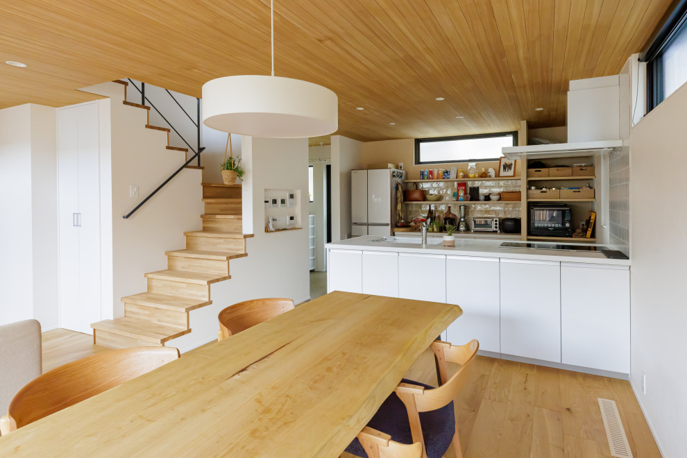 Idée de décoration pour une cuisine ouverte linéaire champêtre de taille moyenne avec un plan de travail blanc et un plafond en bois.