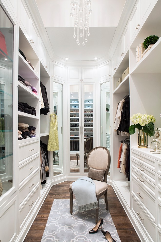 Example of a large classic women's brown floor and dark wood floor dressing room design in Los Angeles with open cabinets and white cabinets