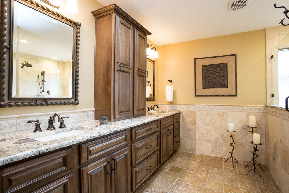 Large country master bathroom in Albuquerque with raised-panel cabinets, dark wood cabinets, an open shower, beige tile, stone tile, yellow walls, travertine floors, an undermount sink, granite benchtops, beige floor and an open shower.