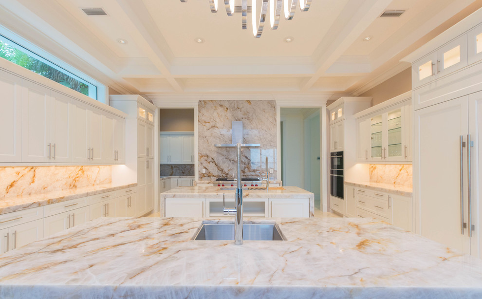 Huge transitional u-shaped marble floor and white floor open concept kitchen photo with an undermount sink, flat-panel cabinets, white cabinets, quartzite countertops, white backsplash, stone slab backsplash and two islands