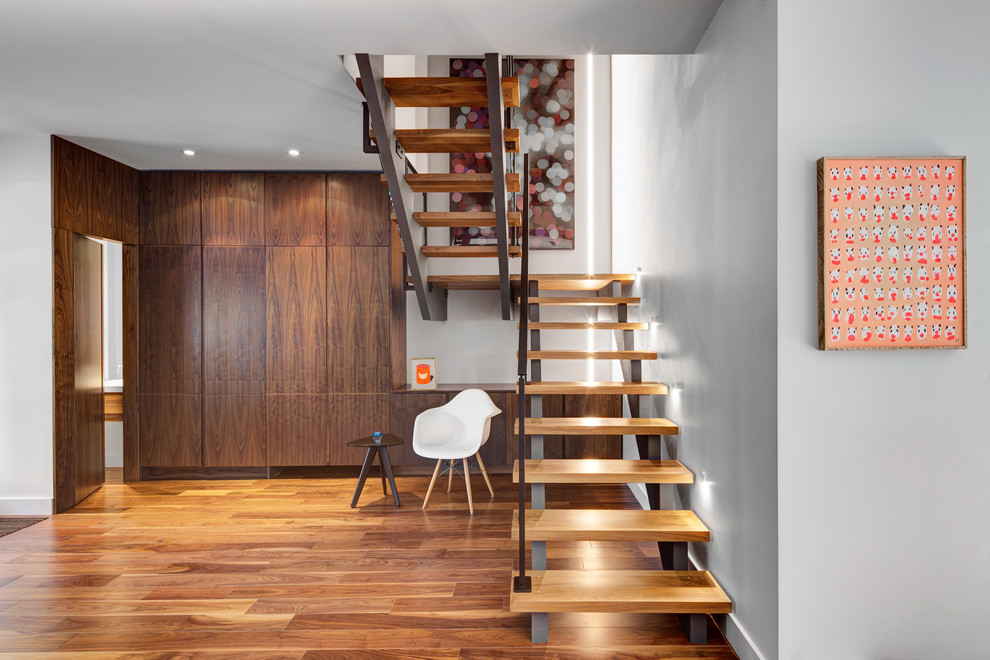 Photo of a mid-sized contemporary wood u-shaped staircase in Toronto with open risers.