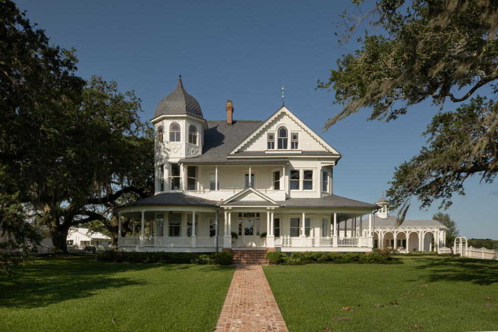 Photo of an expansive and white victorian detached house in Houston with three floors, wood cladding, a pitched roof, a shingle roof and a grey roof.
