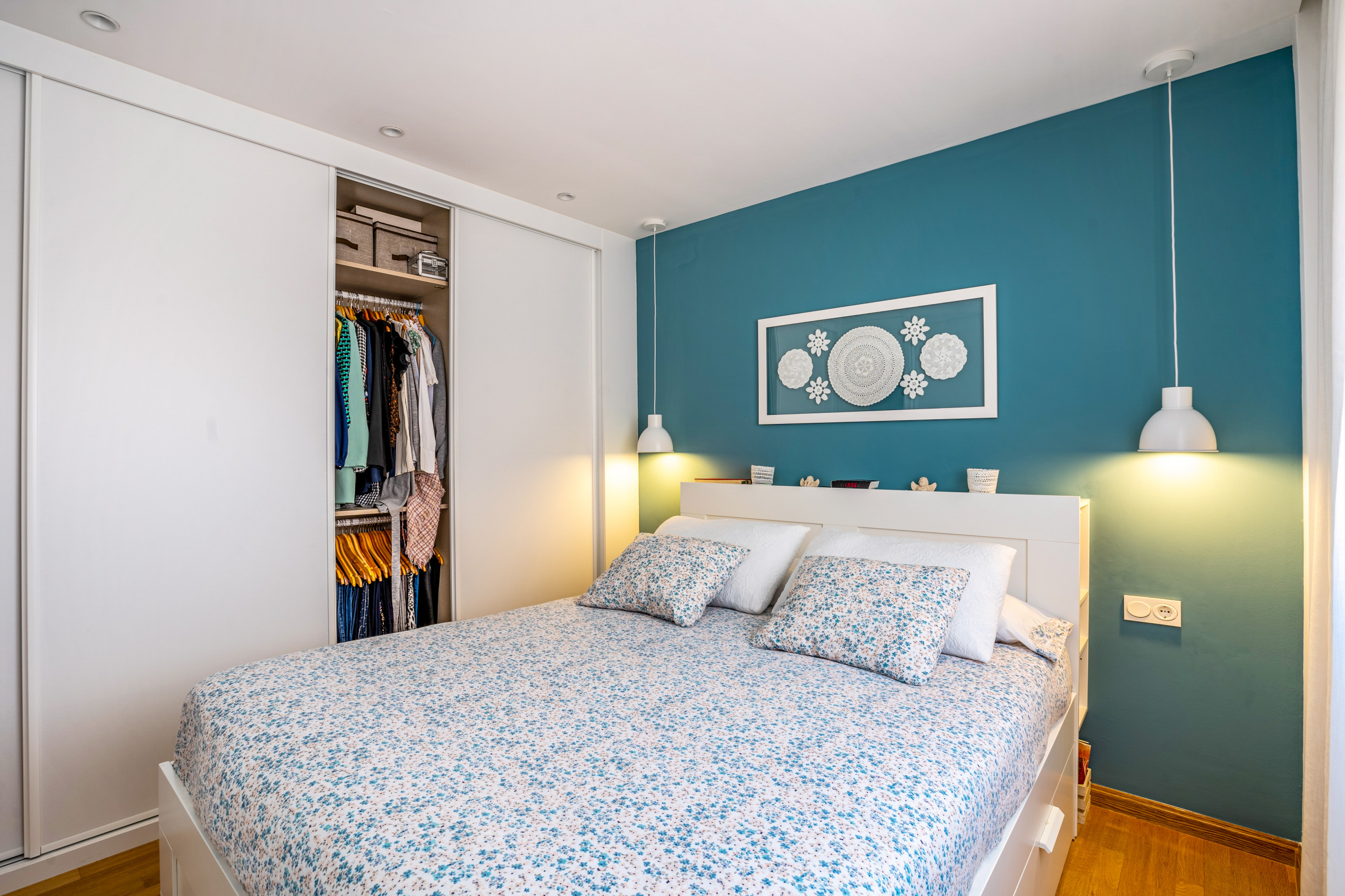 Dormitorio y vestidor con pared cabecero en color
