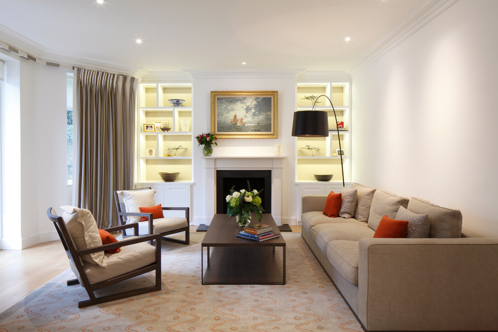 This is an example of a transitional enclosed living room in London with white walls and a standard fireplace.