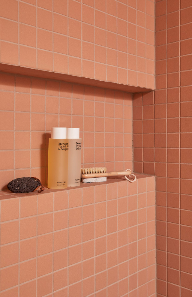 Пример оригинального дизайна: маленькая ванная комната в стиле ретро с светлыми деревянными фасадами, душем без бортиков, унитазом-моноблоком, розовой плиткой, керамической плиткой, розовыми стенами, полом из керамической плитки, врезной раковиной, столешницей из искусственного кварца, розовым полом, душем с распашными дверями, серой столешницей, нишей, тумбой под одну раковину и подвесной тумбой для на участке и в саду