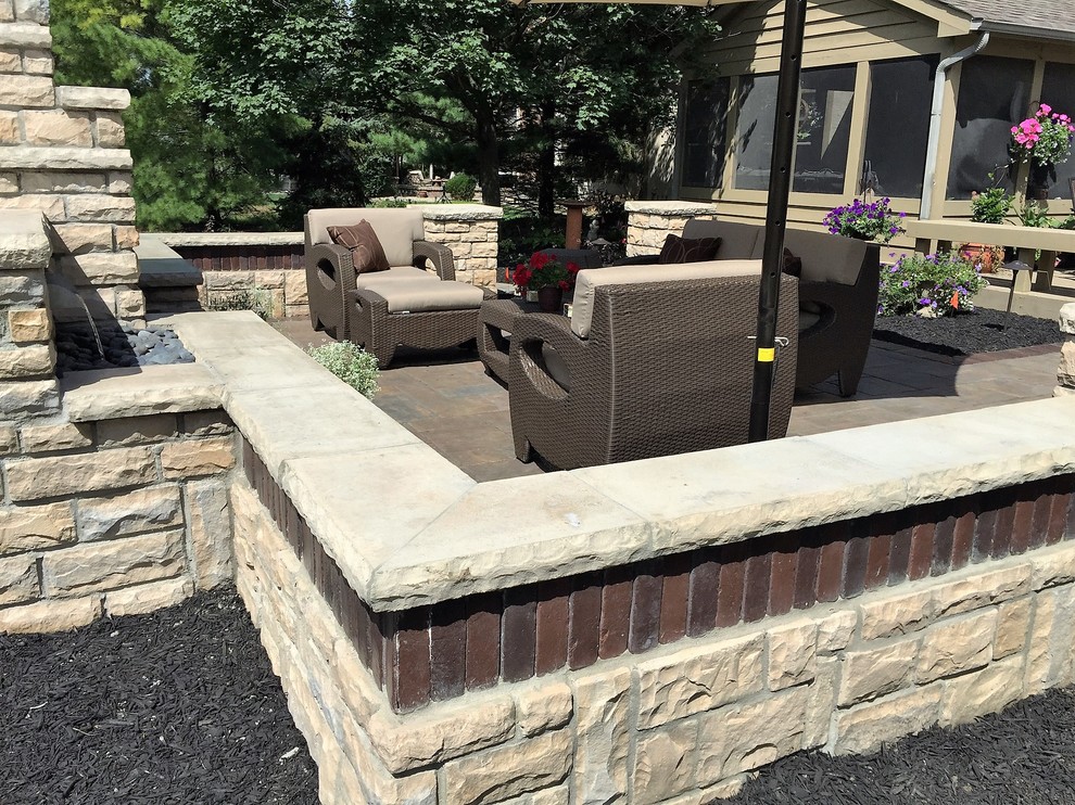 Inspiration for a mid-sized traditional backyard patio in Columbus with a fire feature, concrete pavers and no cover.