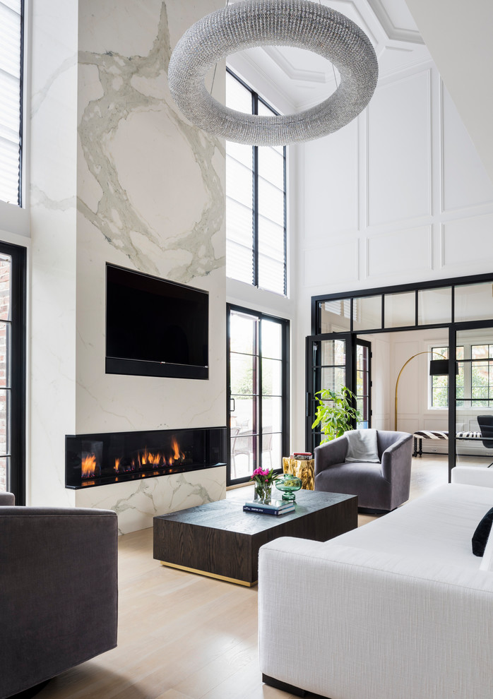 Large transitional open concept living room in New York with white walls, light hardwood floors, a ribbon fireplace, a stone fireplace surround, a built-in media wall and beige floor.