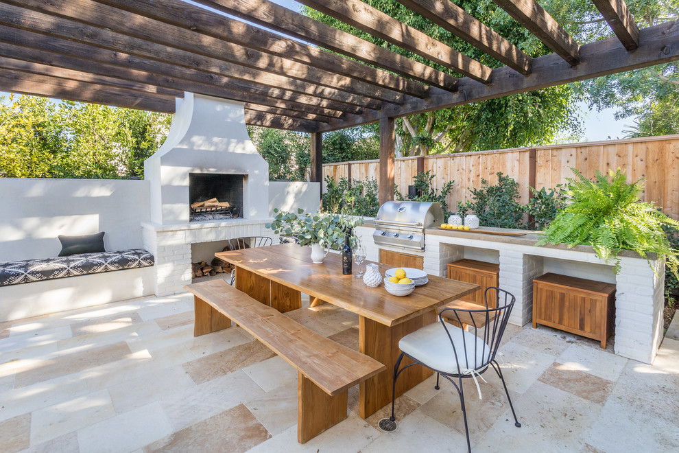 This is an example of a mediterranean patio in Orange County with tile, a pergola and with fireplace.