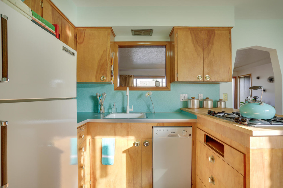 Mid-sized midcentury u-shaped eat-in kitchen in Portland with a drop-in sink, flat-panel cabinets, light wood cabinets, laminate benchtops, blue splashback, white appliances, linoleum floors, a peninsula and turquoise floor.