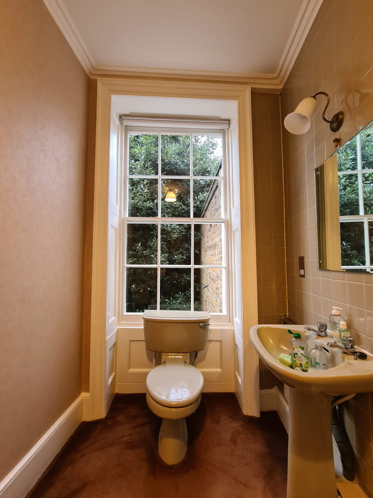 This is an example of a medium sized traditional ensuite bathroom in London with white cabinets, a built-in bath, an alcove shower, a one-piece toilet, beige tiles, ceramic tiles, beige walls, a pedestal sink, a shower curtain, a single sink, a freestanding vanity unit, a coffered ceiling and wallpapered walls.