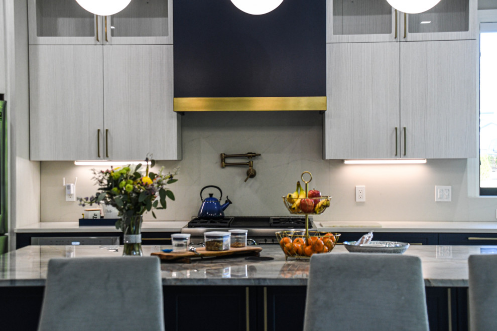 This is an example of a large contemporary u-shaped eat-in kitchen in Detroit with an undermount sink, flat-panel cabinets, blue cabinets, marble benchtops, stainless steel appliances, porcelain floors, with island, white floor and blue benchtop.